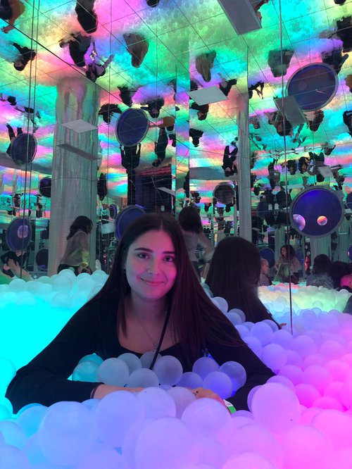 Girl in a ball pit with fluorescent lights